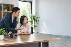 Chủ doanh nghiệp Việt Nam cùng chuyên viên tư vấn kiểm tra tổng quan các nguồn lực kỹ thuật của website cũ trong không gian làm việc, tập trung vào việc đánh giá tài sản cần chuẩn
